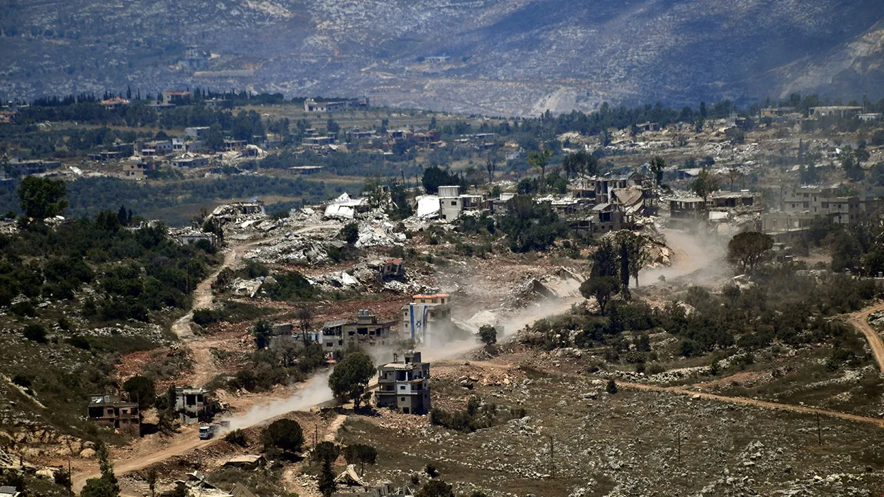 Israeli military vehicles and an Israeli flag, seen in a village inside south Lebanon close to the border as seen from northern Israel, June 18, 2026. REUTERS/Gil Eliyahu