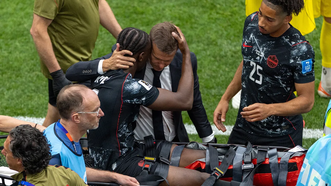 Canada head coach Jesse Marsch embraces Ismael Kone (8) as he is stretchered off the field after an injury during the World Cup Group B soccer match between Canada and Qatar in Vancouver, British Columbia, Thursday, June 18, 2026. (Timothy Matwey/The Canadian Press via AP)