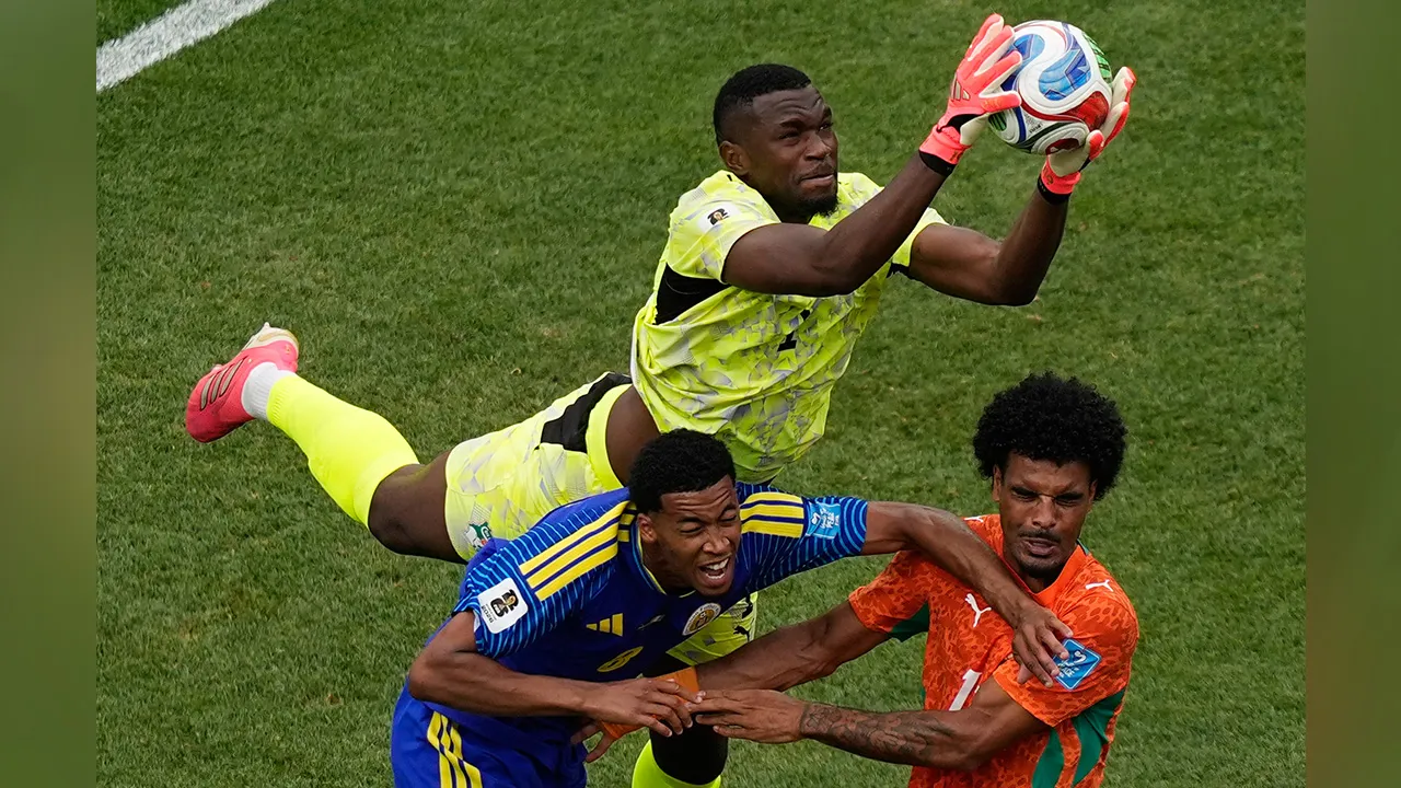 Ivory Coast goalkeeper Yahia Fofana (1) makes a save in front of Curaçao's Livano Comenencia (8) and Ivory Coast's Christopher Operi (13) during the World Cup Group E soccer match between Curacao and Ivory Coast in Philadelphia, Thursday, June 25, 2026. (AP Photo/Matt Slocum)