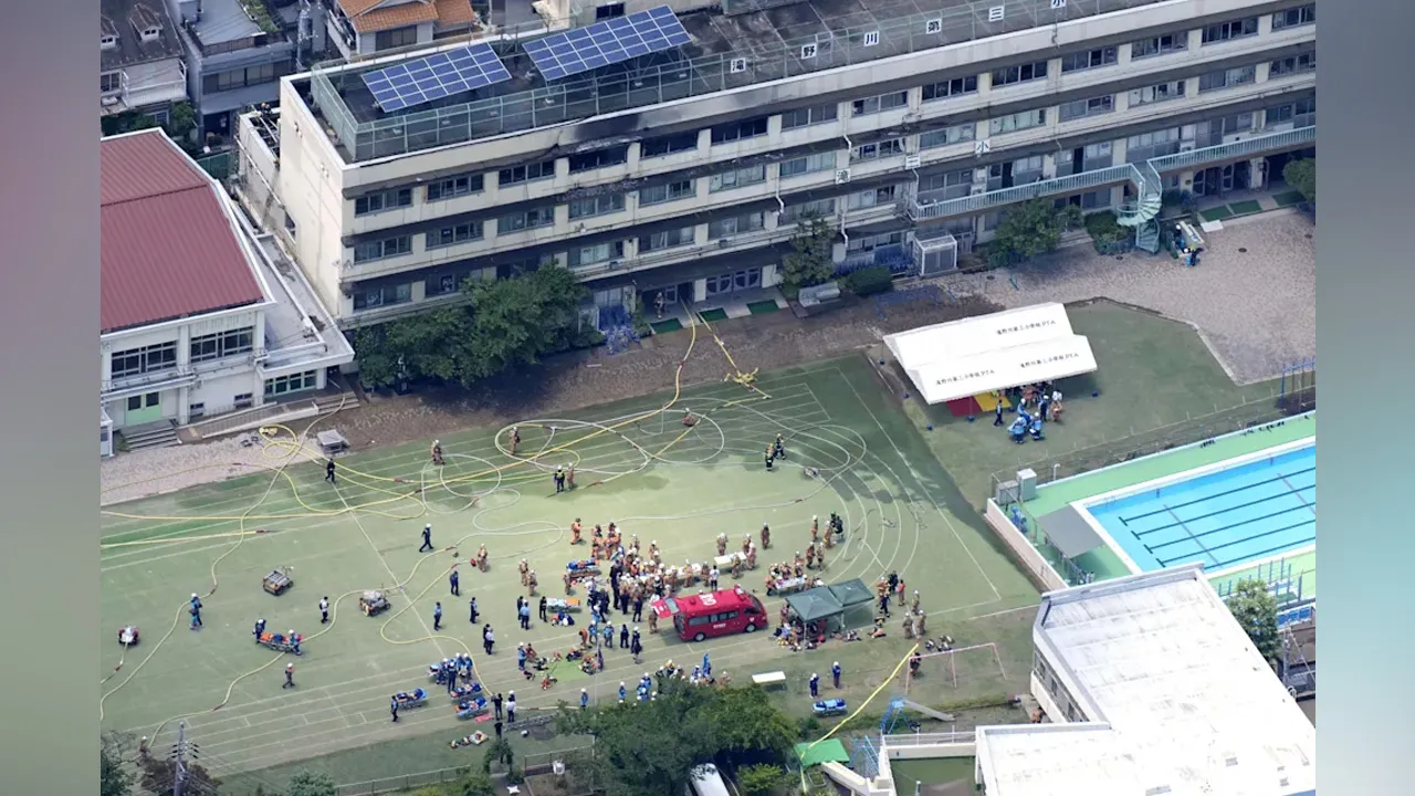 Firefighters and rescuers work at the site of a fire at an elementary school in Tokyo, Friday, June 19, 2026. (Kyodo News via AP)