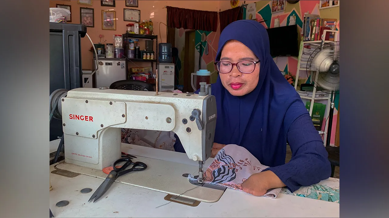 PASIR PUTEH, 17 Jun -- Tukang jahit Orang Kelainan Upaya (OKU) kategori fizikal Liza Mamat, 46, melakukan kerja-kerja menjahit baju yang telah dipotong mengikut citarasa dan kehendak pelanggan ketika ditemui Bernama di Kampung Tasek, Bukit Jawa baru-baru ini.  Dilahirkan tanpa kelima-lima jari tangan kiri tidak pernah menghalangnya untuk membina kehidupan berdikari menerusi bidang jahitan yang kini menjadi sumber rezekinya sejak lebih 23 tahun lalu.  Kekurangan fizikal yang dialaminya sejak lahir bukan alas