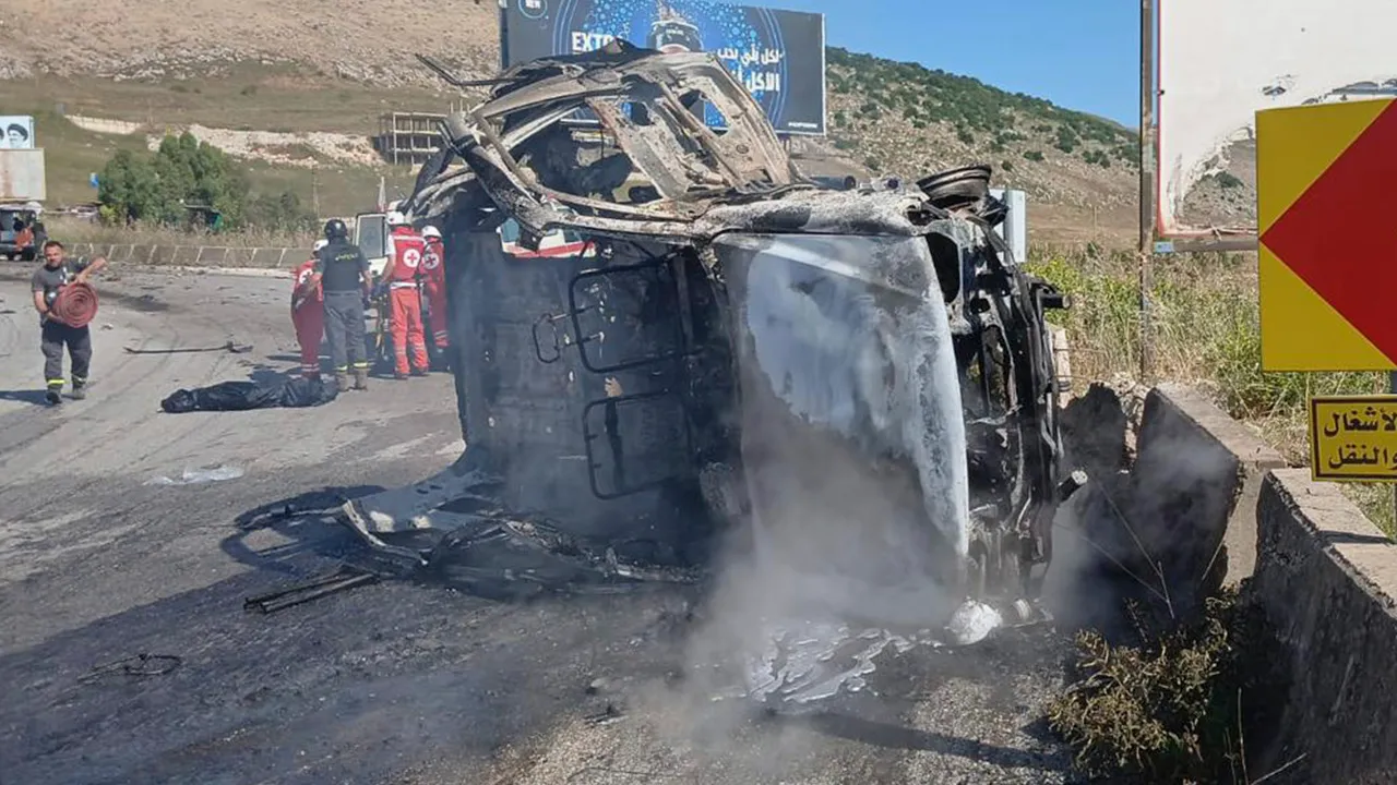 In this image released by the Lebanese Army on its official X account, Lebanese Red Cross personnel and rescue workers stand next to a destroyed vehicle after an Israeli airstrike on the road linking the city of Nabatiyeh and the town of Marjayoun, in Kfar Tebnit, Lebanon, Saturday, June 6, 2026, where, the Lebanese Army said, the vehicle belonged to the army and a brigadier general, a captain and another soldier were killed in the strike. (Lebanese Army via AP)
