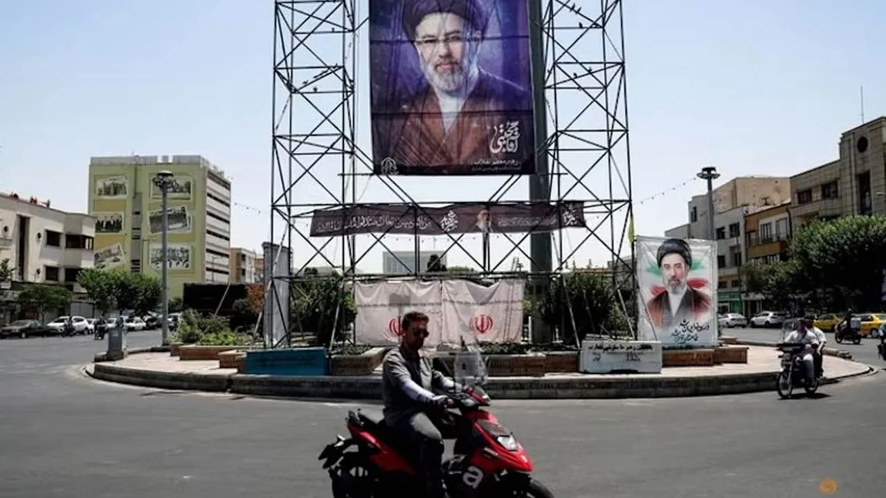 People ride past a banner with a picture of Iran's Supreme Leader, Mojtaba Khamenei, in Tehran, Iran, Jun 28, 2026. (Photo: REUTERS/Majid Asgaripour)