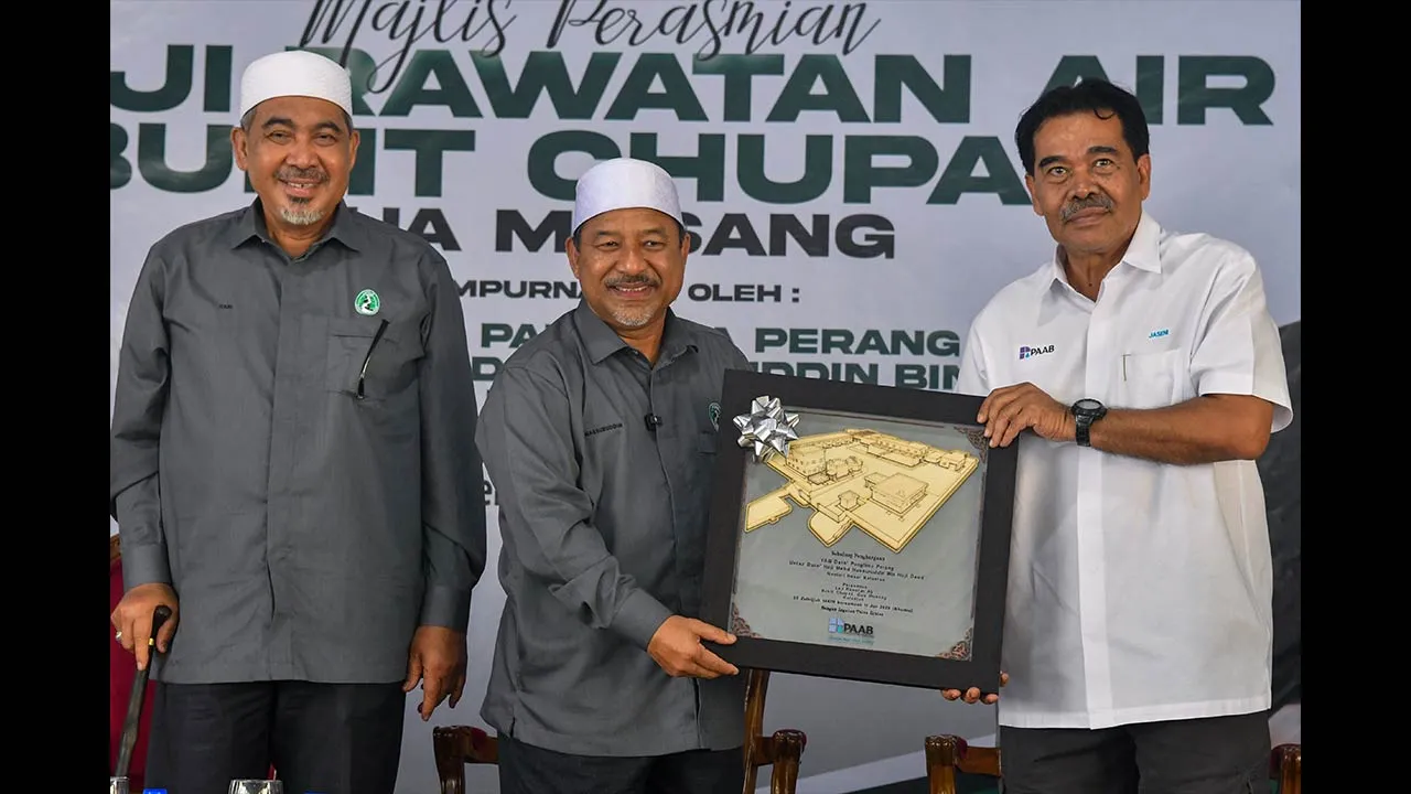 GUA MUSANG, 11 Jun -- Menteri Besar Kelantan Datuk Mohd Nassaruddin Daud (tengah) menerima cenderahati daripada Pengerusi Pengurusan Aset Air Berhad (PAAB) Datuk Seri Jaseni Maidinsa pada Perasmian Loji Rawatan Air (LRA), Bukit Chupak hari ini.