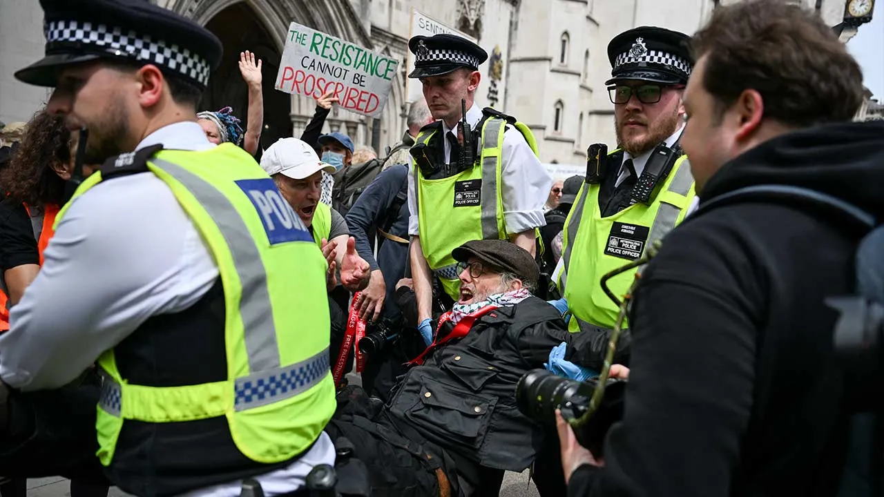 Police officers detain a demonstrator opposing the government's decision to ban Palestine Action as a terror organisation, following a Court of Appeal ruling on the lawfulness of proscribing the pro-Palestinian group under terrorism laws, outside the Royal Courts of Justice, in London, Britain, June 15, 2026. REUTERS/Chris J. Ratcliffe