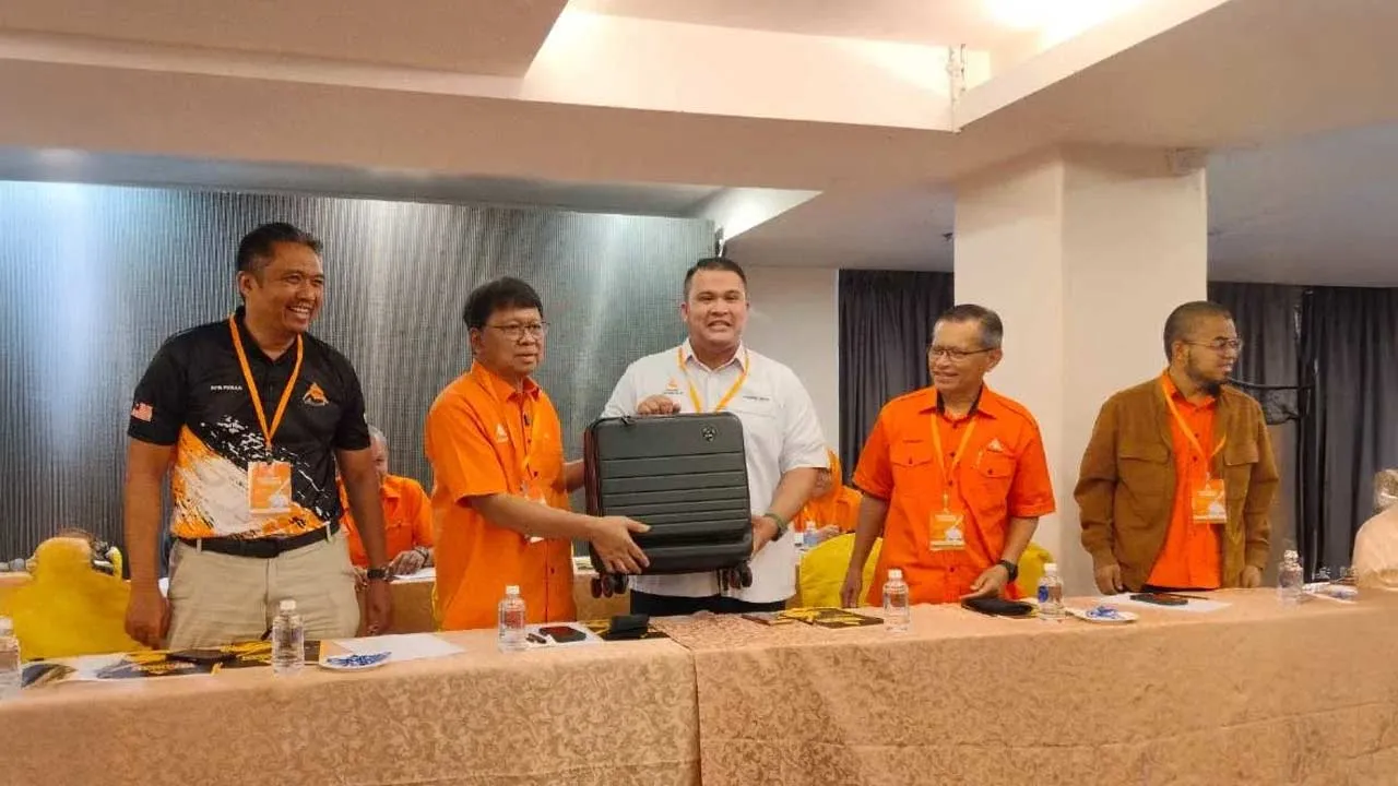Khairol Najib (tiga dari kanan) menerima cenderahati daripada Asmuni selepas merasmikan Mesyuarat Tahunan Amanah Kawasan Tambun di sebuah hotel di sini pada Ahad.