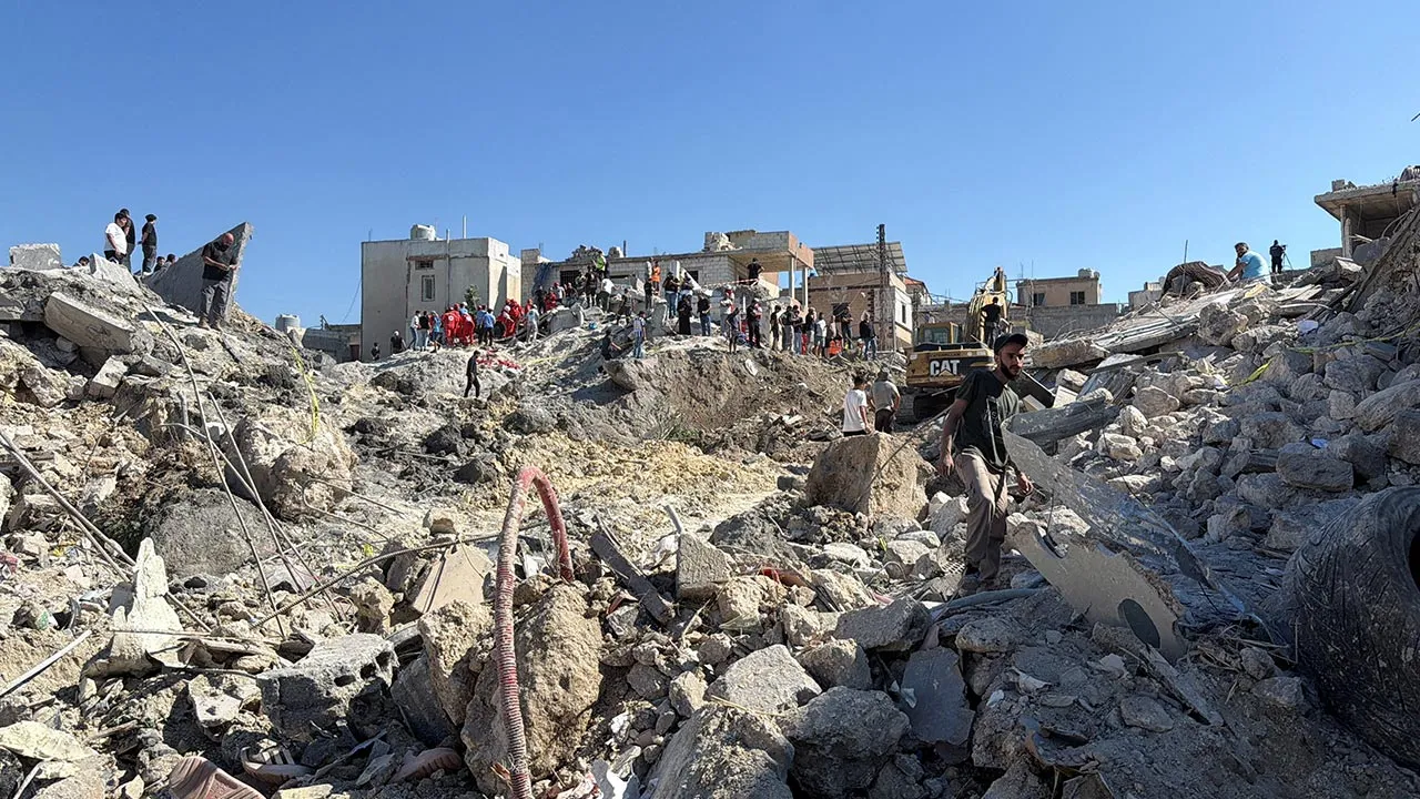 Civilians and Lebanese Red Cross personnel stand on the rubble of a damaged building after an Israeli strike on the village of Qennarit in southern Lebanon, June 20, 2026. Picture taken with a mobile phone. REUTERS/Stringer