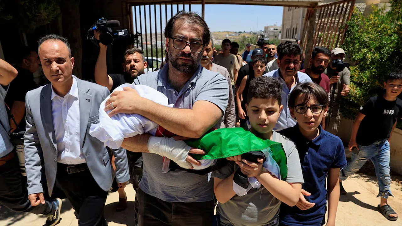 Father and brother of Sam Abu Haykal, a 7-month-old Palestinian child who was killed by Israeli soldiers, carry his body during his funeral in Hebron in the Israeli-occupied West Bank, June 6, 2026. REUTERS/Mussa Qawasma 