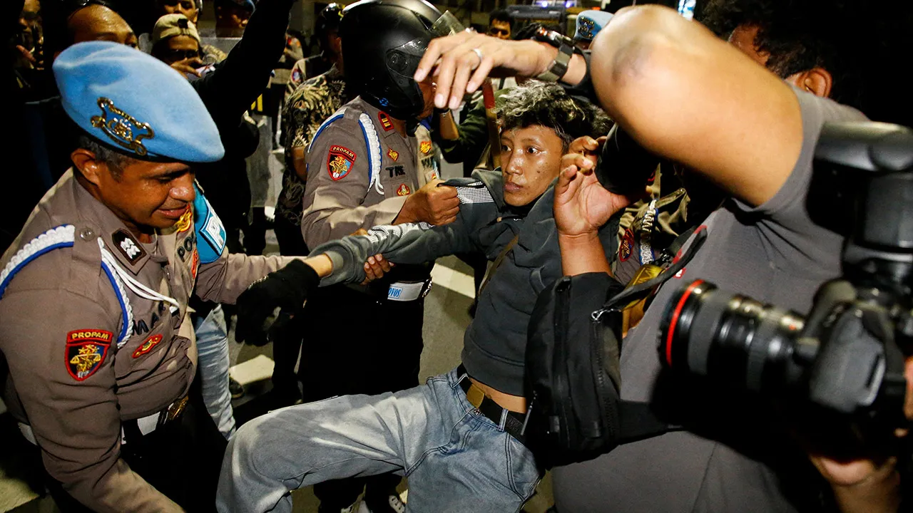 A protester is detained during a protest against government policies, including state budget spending, fuel price hike, free meals programme, and expanded military roles in civilian affairs, outside Grahadi State building in Surabaya, East Java province, Indonesia, June 26, 2026. REUTERS/Dipta Wahyu