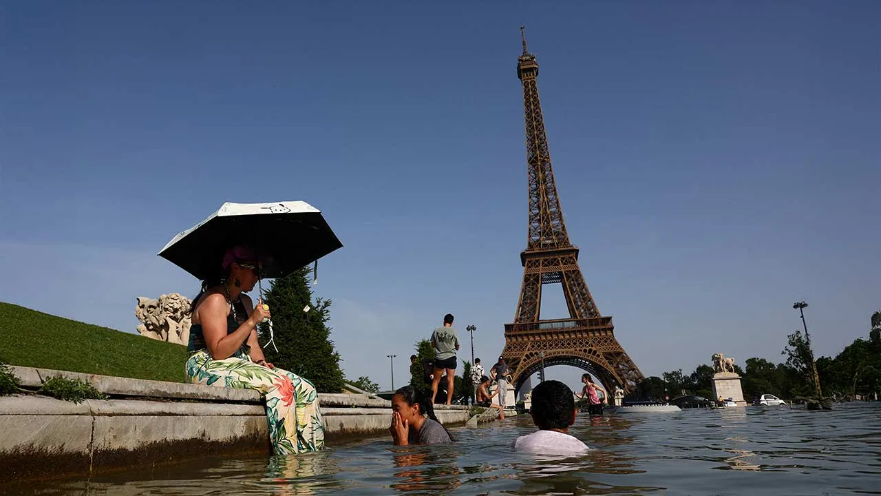 People cool off in the Trocadero fountain in front of the Eiffel Tower as temperatures rise in Paris during a heatwave affecting a large part of France, June 23, 2026. REUTERS/Abdul Saboor