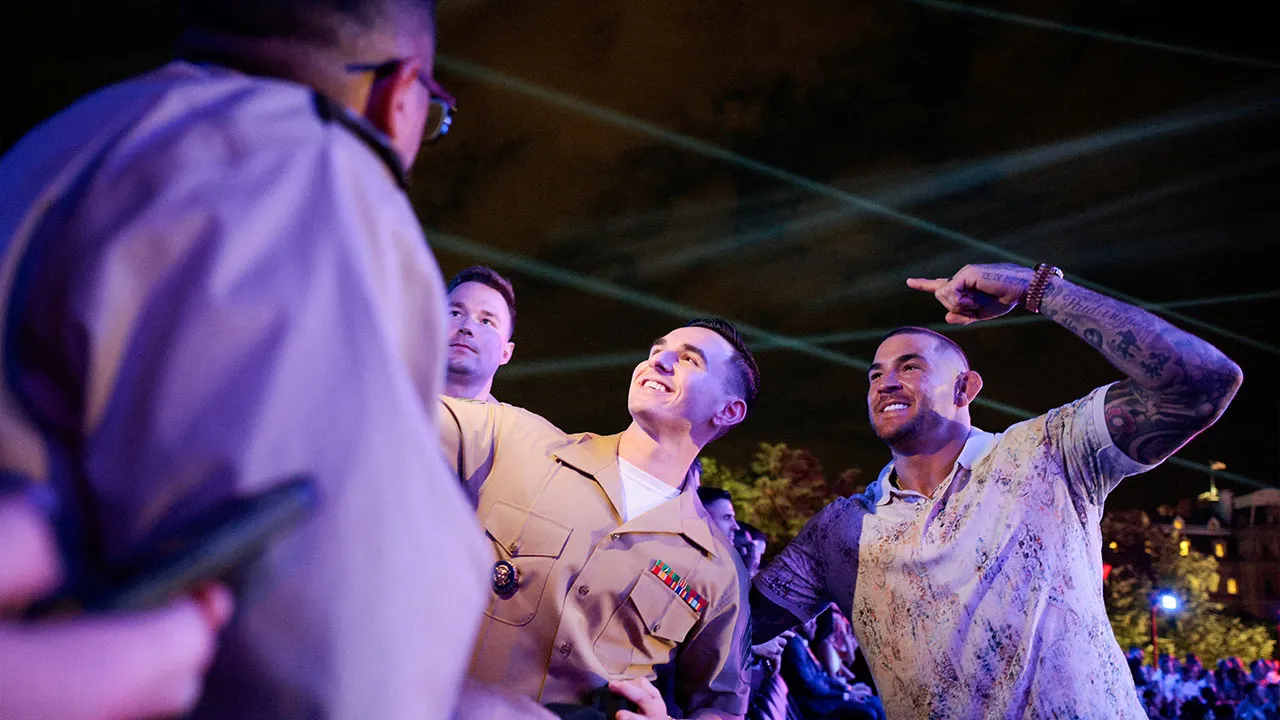 Former UFC champion Dustin Poirier gestures next to members of the U.S. military attending UFC Freedom 250 on the South Lawn of the White House in Washington, D.C., U.S., June 14, 2026. REUTERS/Evan Vucci