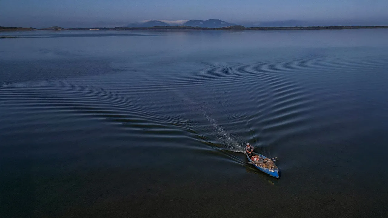 A drone view shows a fisherman sailing his boat near the Vjosa-Narta Protected Area, where a luxury resort is planned by a company linked to Donald Trump's son-in-law, Jared Kushner, in Zvernec near Vlora, Albania, June 10, 2026. REUTERS/Florion Goga