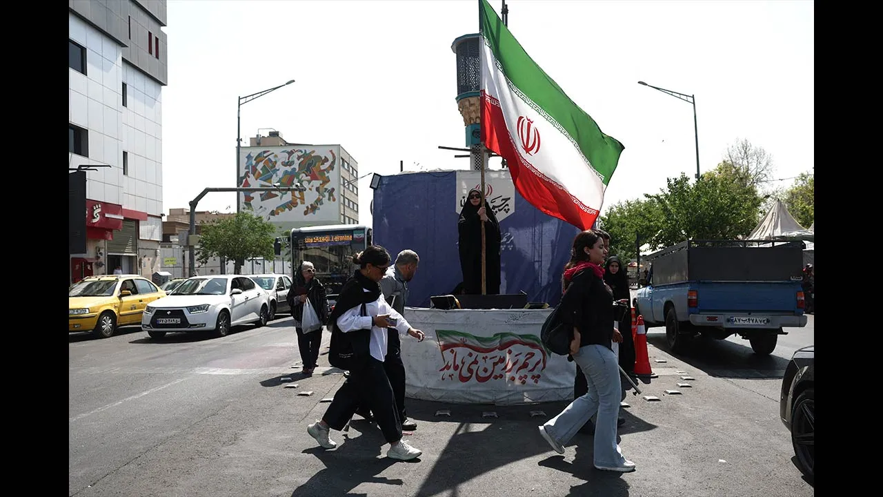A woman holds an Iranian flag on a street in Tehran, Iran, June 10, 2026. Majid Asgaripour/WANA (West Asia News Agency) via REUTERS ATTENTION EDITORS - THIS PICTURE WAS PROVIDED BY A THIRD PARTY
