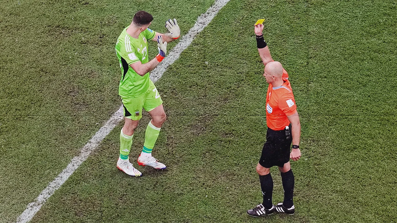 FILE - Referee Szymon Marciniak, of Poland, shows a yellow card to Argentina's goalkeeper Emiliano Martinez during the penalty shootout inthe World Cup final soccer match between Argentina and France at the Lusail Stadium in Lusail, Qatar, Sunday, Dec. 18, 2022. (AP Photo/Thanassis Stavrakis, File)