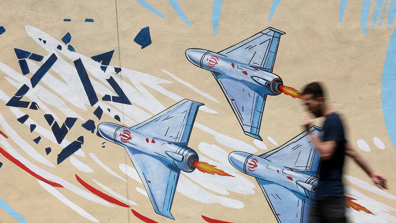 An Iranian man walks next to an anti-Israeli mural on a street in Tehran, Iran June 6, 2026_REUTERS