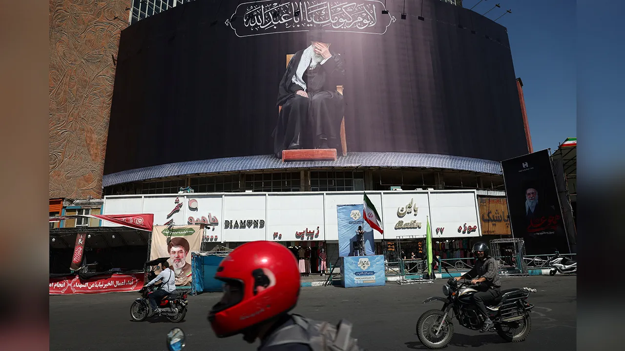 People drive past a billboard with a picture of the late Iran's Supreme Leader Ayatollah Ali Khamenei, after U.S. and Iranian officials said they had reached a deal to end their war and reopen the Strait of Hormuz, in Tehran, Iran, June 15, 2026. Majid Asgaripour/WANA (West Asia News Agency) via REUTERS ATTENTION EDITORS - THIS PICTURE WAS PROVIDED BY A THIRD PARTY. ISRAEL OUT. NO COMMERCIAL OR EDITORIAL SALES IN ISRAEL. NO ACCESS FOR ISRAELI MEDIA. NO USE BBC PERSIAN. NO USE VOA PERSIAN. NO USE MANOTO. NO 