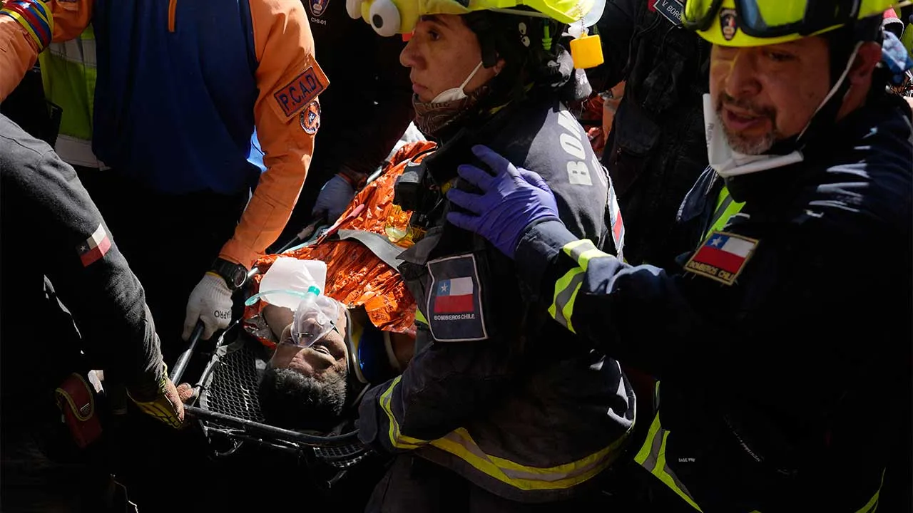 Chilean rescue workers carry Hernán Alberto Gil Flores after he was pulled from the rubble eight days after he was trapped by twin earthquakes that struck Catia La Mar, Venezuela, Thursday, July 2, 2026. (AP Photo/Fernando Vergara)
