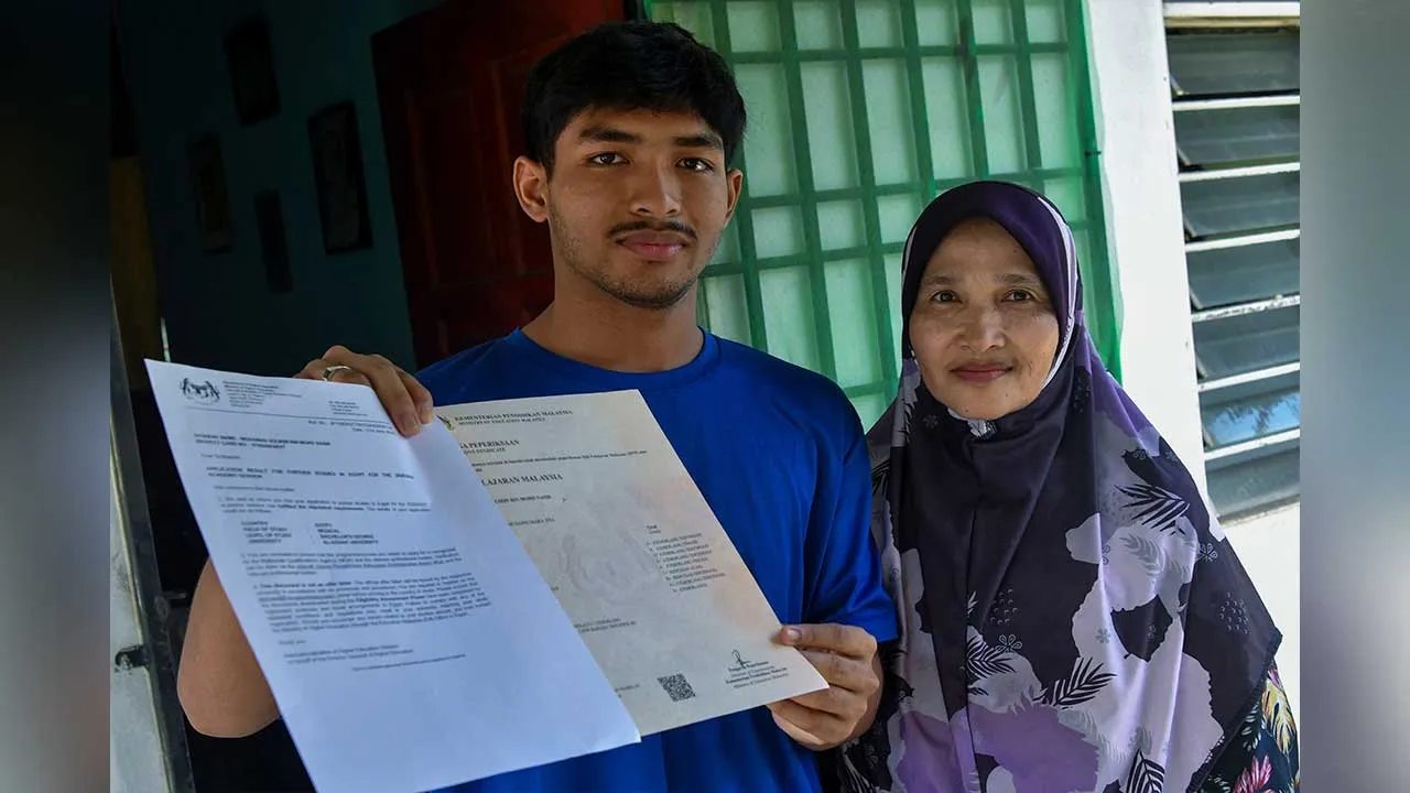 KOTA BHARU, 5 Julai -- Bekas pelajar Maktab Rendah Sains MARA (MRSM) Jeli, Mohamad Solihin Mohd Nasir, 19, (kiri) ditemani ibunya, Faridah Mohamad, 60, menunjukkan surat tawaran pengajian dan Sijil Pelajar Malaysia (SPM) ketika ditemui pemberita di Kampung Kubang Keranji, Pasir Tumboh hari ini.  Impian untuk melanjutkan pengajian dalam bidang perubatan di Universiti Al-Azhar, Mesir hampir terkubur apabila keluarganya tidak mampu menyediakan kos kira-kira RM30,000 bagi menampung perbelanjaan tahun pertama pe