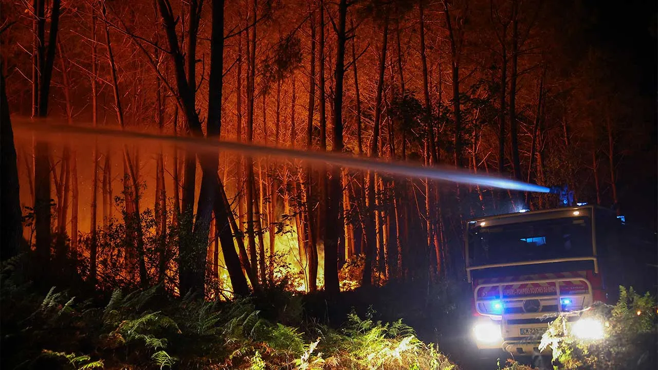 A fire engine works to extinguish flames, as a wildfire burns near Lacanau, Gironde, amongst worsening drought conditions following a heatwave and water shortages across much of France, July 25, 2026. REUTERS/Abdul Saboor