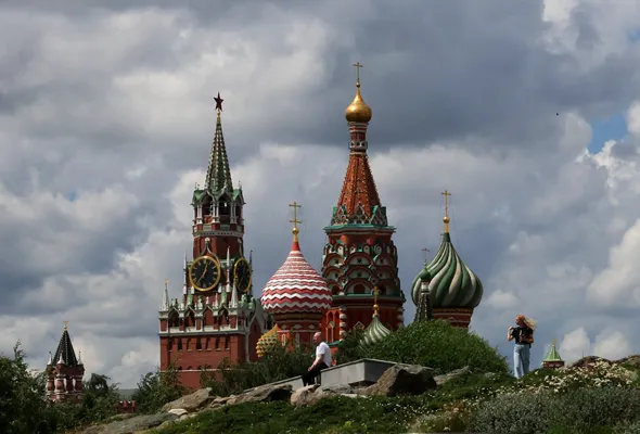 People walk in Zaryadye Park near St. Basil's Cathedral and the Kremlin's Spasskaya Tower in central Moscow, Russia, July 6, 2026. REUTERS/Anastasia Barashkova