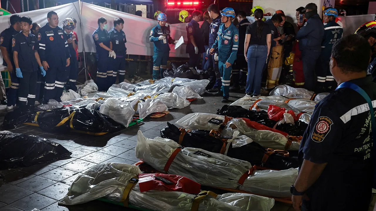 Members of emergency personnel work next to covered bodies at the site of a deadly fire at a pub in Bangkok, Thailand, July 13, 2026. REUTERS/Chalinee Thirasupa