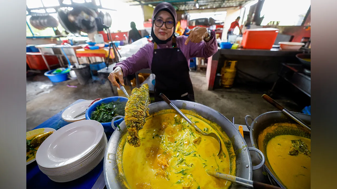 PORT DICKSON, 22 Julai -- Pemilik Warung Dayang Salai D’Linggi, Rozianah Ahmad, 57, menyiapkan hidangan ikan baung salai ketika ditemui fotoBernama baru-baru ini.  Kuah kuning keemasan yang pekat menyelimuti isi baung salai yang lembut, dengan rasa lemak santan segar, pedas cili api kampung serta aroma daun kesum berpadu menghasilkan hidangan yang cukup membuka selera.  Aroma salai yang masih melekat pada isi ikan memberikan cita rasa tersendiri kepada masak lemak cili api yang diwarisi daripada resipi oran