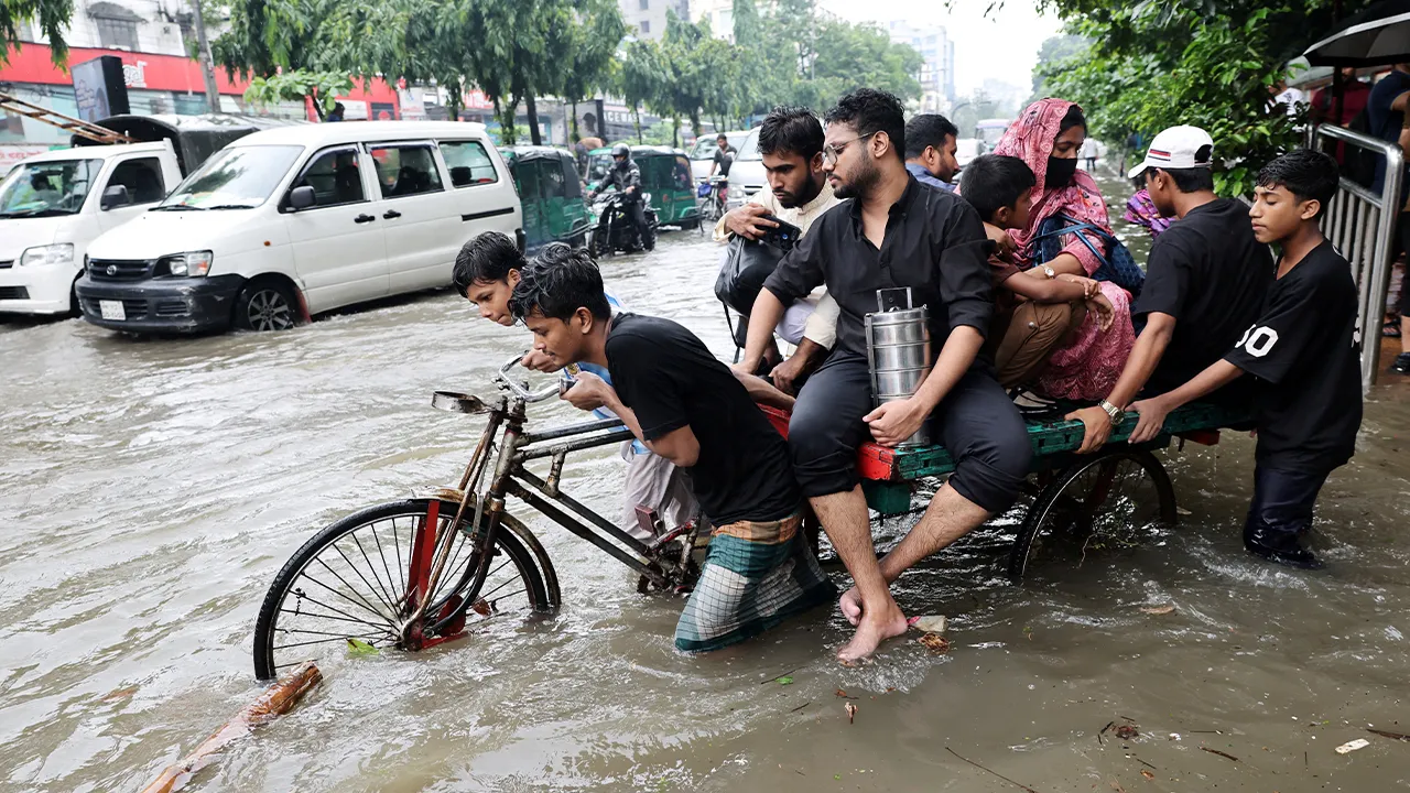 People cross a flooded street on tricycle following torrential rain in Dhaka, Bangladesh, July 12, 2026. REUTERS/Mohammad Ponir Hossain TPX IMAGES OF THE DAY