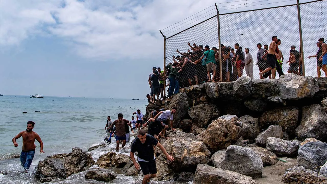 Migrants cross from Morocco into the Spanish enclave of Ceuta, Thursday, July 30, 2026. (AP Photo/Antonio Sempere)