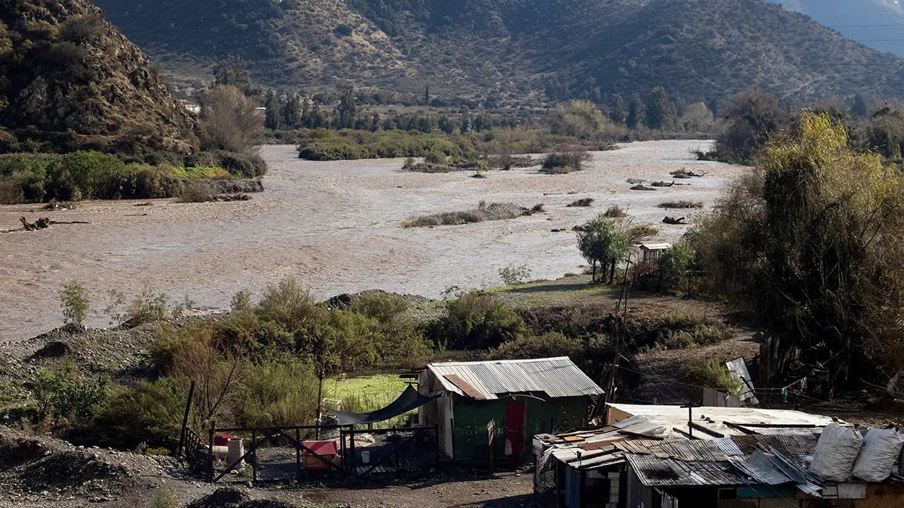 A view of houses on the banks of the Mapocho River following heavy rainfall from a weather front that caused flooding and prompted Chilean authorities to declare a preventive state of emergency earlier in the week, in Talagante, Chile, July 18, 2026. REUTERS/Diego Reyes