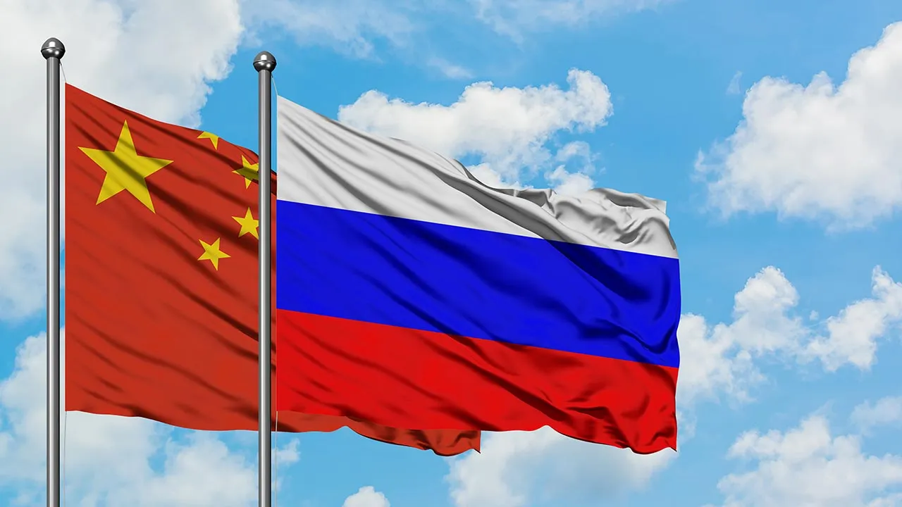 China and Russia flag waving in the wind against white cloudy blue sky together. Diplomacy concept, international relations. -- Adobe Stock