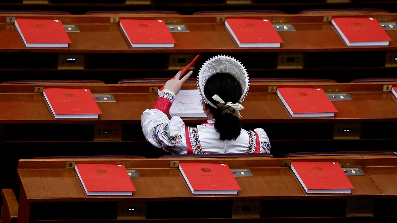 FILE PHOTO: A delegate in an ethnic minority costume arrives before the closing session of the National People's Congress at the Great Hall of the People in Beijing, China March 12, 2026. REUTERS/Tingshu Wang/File Photo
