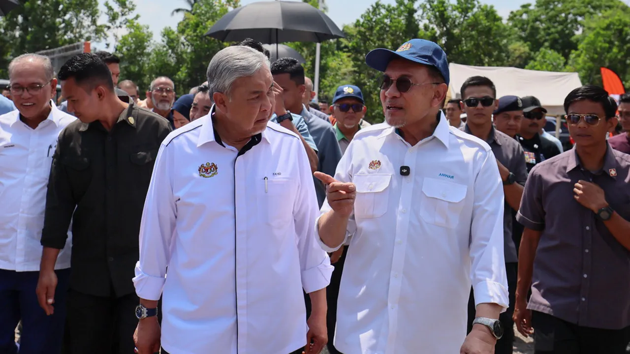 MARAN, 7 Julai -- Perdana Menteri Datuk Seri Anwar Ibrahim (kanan) memperkatakan sesuatu kepada Timbalan Perdana Menteri Datuk Seri Dr Ahmad Zahid Hamidi pada Majlis Perasmian Sambutan Hari Peneroka dan 70 tahun Lembaga Kemajuan Tanah Persekutuan (FELDA) di Stadium Tun Abdul Razak, Jengka, hari ini.  Turut sama Menteri Besar Pahang Datuk Sri Wan Rosdy Wan Ismail (kiri).  -- fotoBERNAMA (2026) HAK CIPTA TERPELIHARA