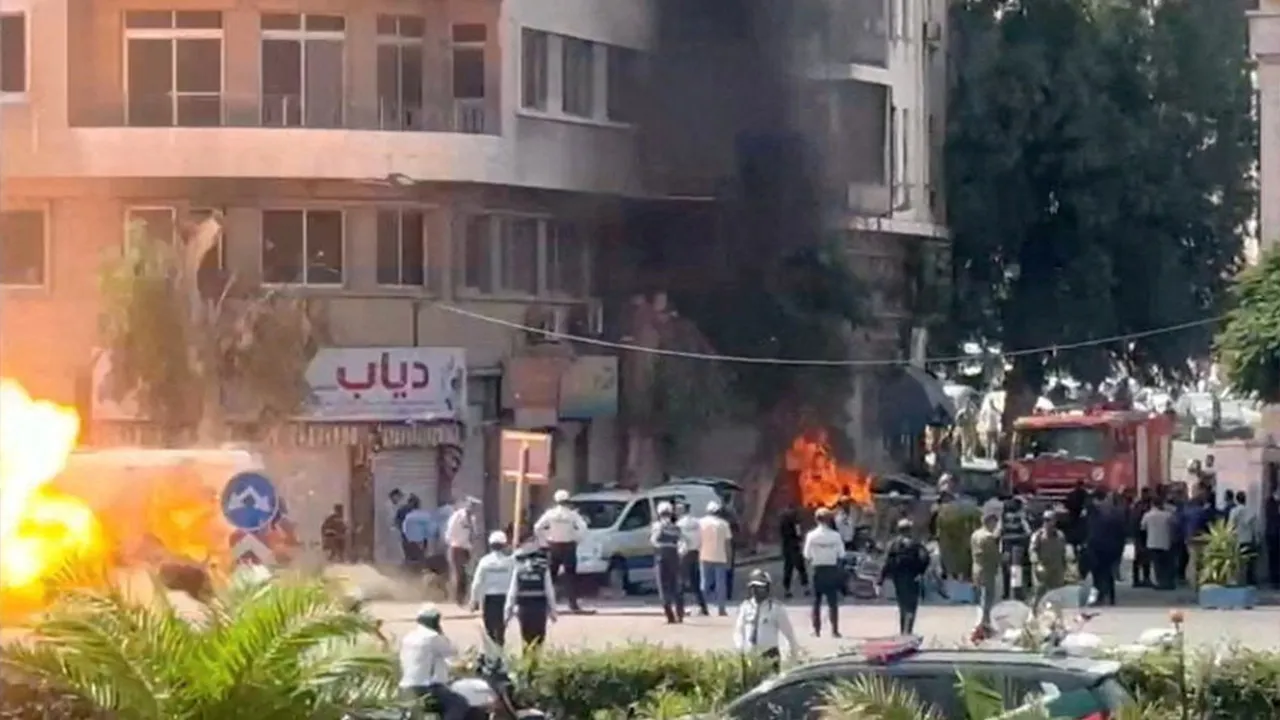 Emergency personnel work as smoke and fire rise at the site where explosive devices blew up near a hotel where French President Emmanuel Macron was meant to be staying, in Damascus, Syria, in this screengrab obtained from a video, July 7, 2026. REUTERS/Yamam Al Shaar 