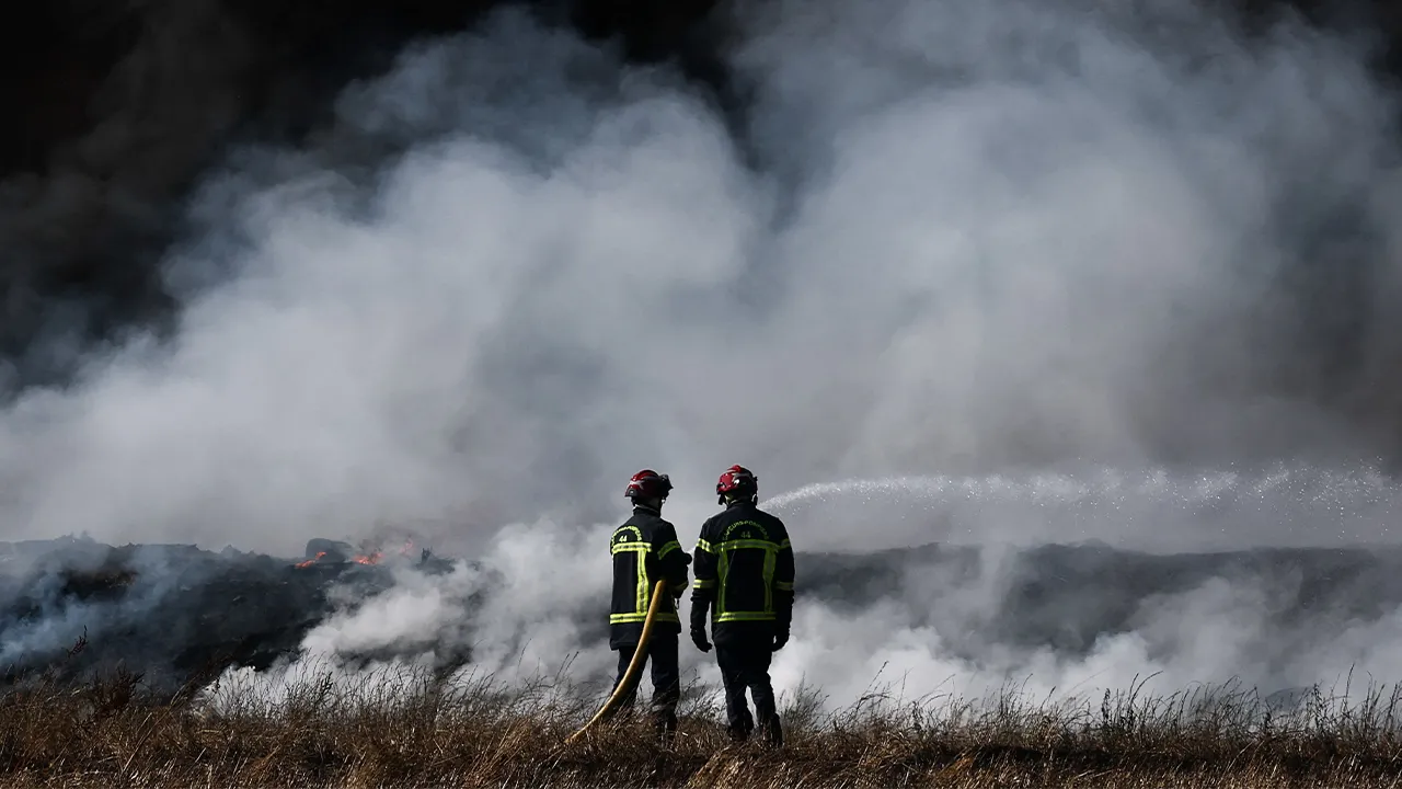 French firefighters work to extinguish a fire near a farm in Grand-Auverne, as drought worsens in Loire-Atlantique, France, June 30, 2026. REUTERS/Stephane Mahe