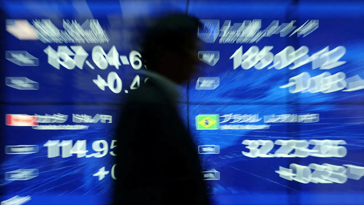 FILE PHOTO: A passersby walks past an electronic screen displaying the current Japanese Yen exchange rate against the U.S. dollar, Euro and other foreign currencies in Tokyo, Japan May 12, 2026. REUTERS/Issei Kato/File Photo