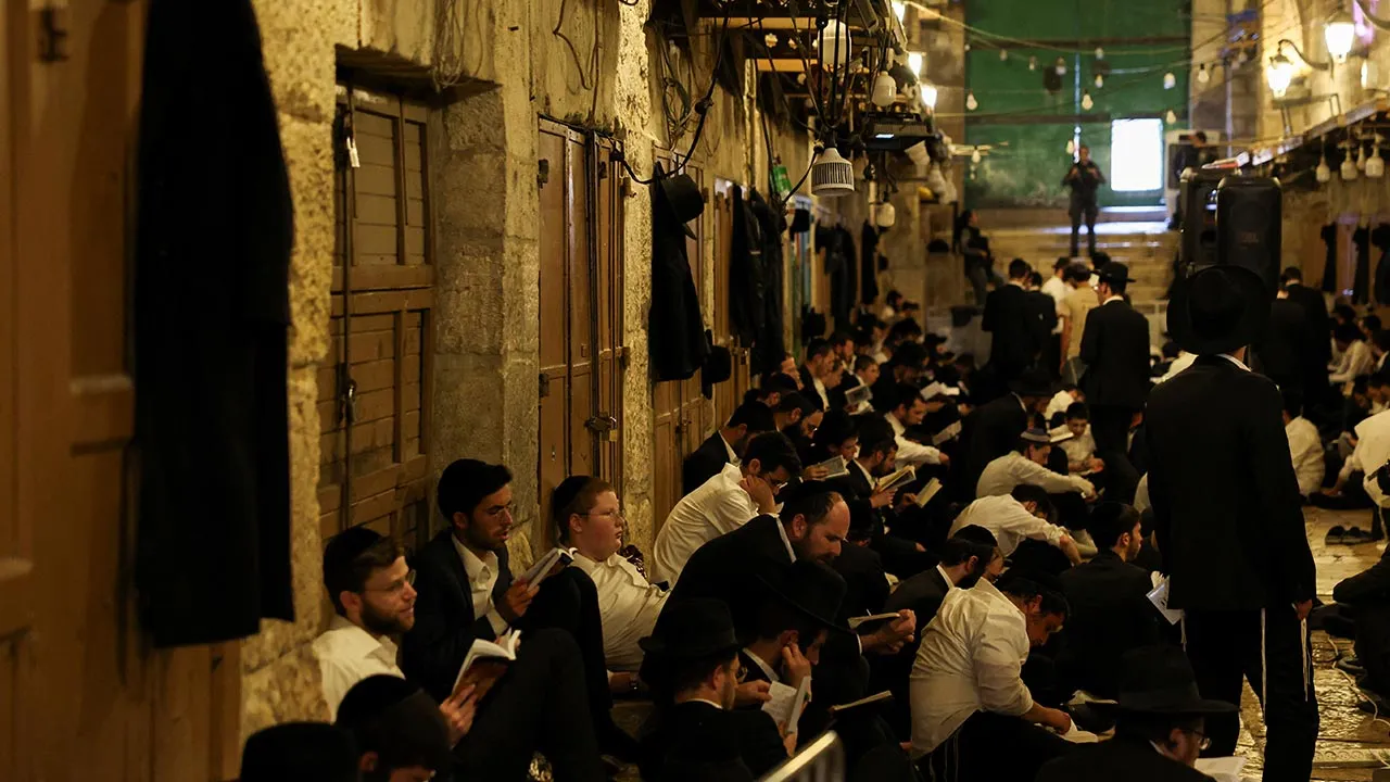 Jewish visitors pray at an entrance of the Al-Aqsa Mosque compound during the holy day Tisha B'Av, a day of fasting and lament, that commemorates the date in the Jewish calendar on which it is believed the First and Second Temples were destroyed, in Jerusalem's Old City, July 23, 2026. REUTERS/Ammar Awad