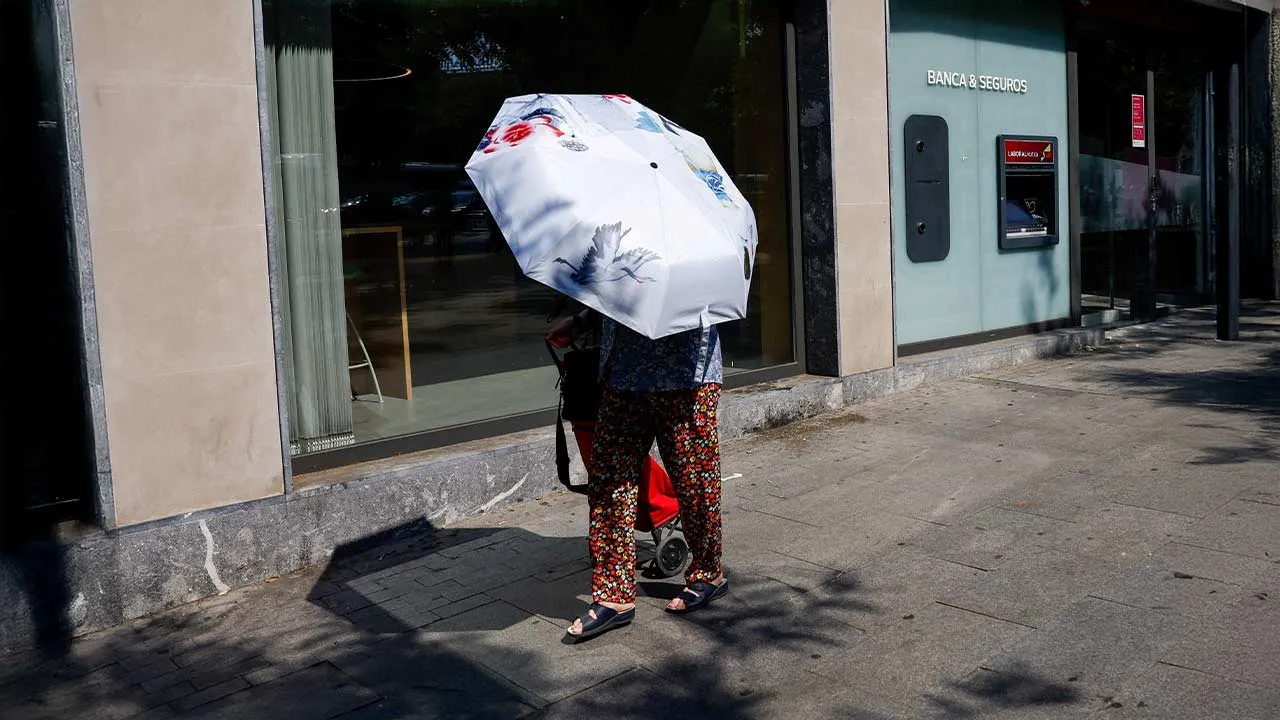 A person uses an umbrella to shield themself from the sun during a heatwave in Madrid, Spain, July 6, 2026. REUTERS/Violeta Santos Moura