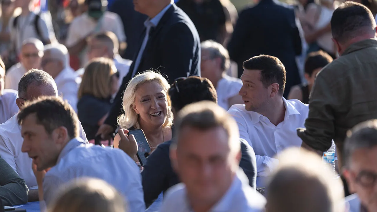 Far-right leader Marine Le Pen, left center, accompanied by far-right party National Rally president Jordan Bardella, right center, attend a rally in Lievin, northern France, Saturday, July 4, 2026. (AP Photo/Jean-Francois Badias)