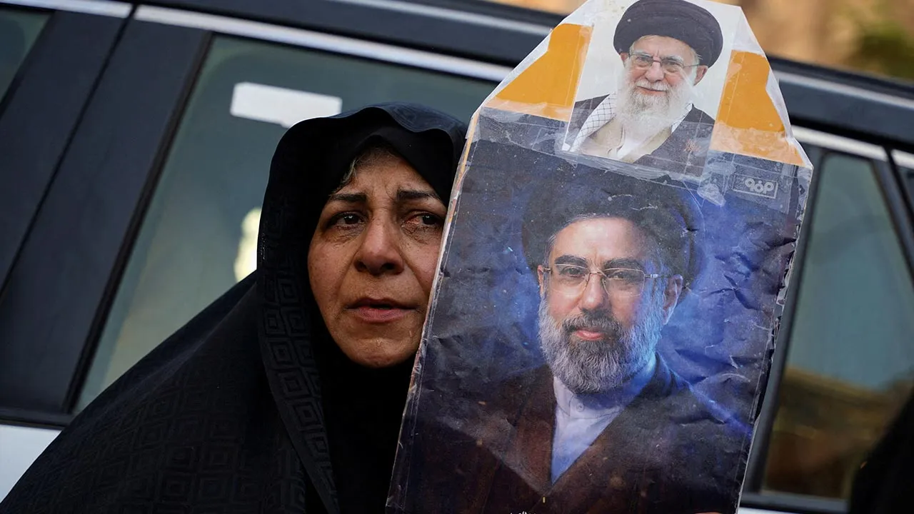 FILE PHOTO: A woman holds a portrait of Iran's Supreme Leader Mojtaba Khamenei and Iran’s late Supreme Leader Ayatollah Ali Khamenei, who was killed on February 28 during Israeli and U.S. airstrikes on Iran, as mourners gather during funeral ceremonies in Karbala, Iraq, July 8, 2026. REUTERS/Teba Sadiq/File Photo