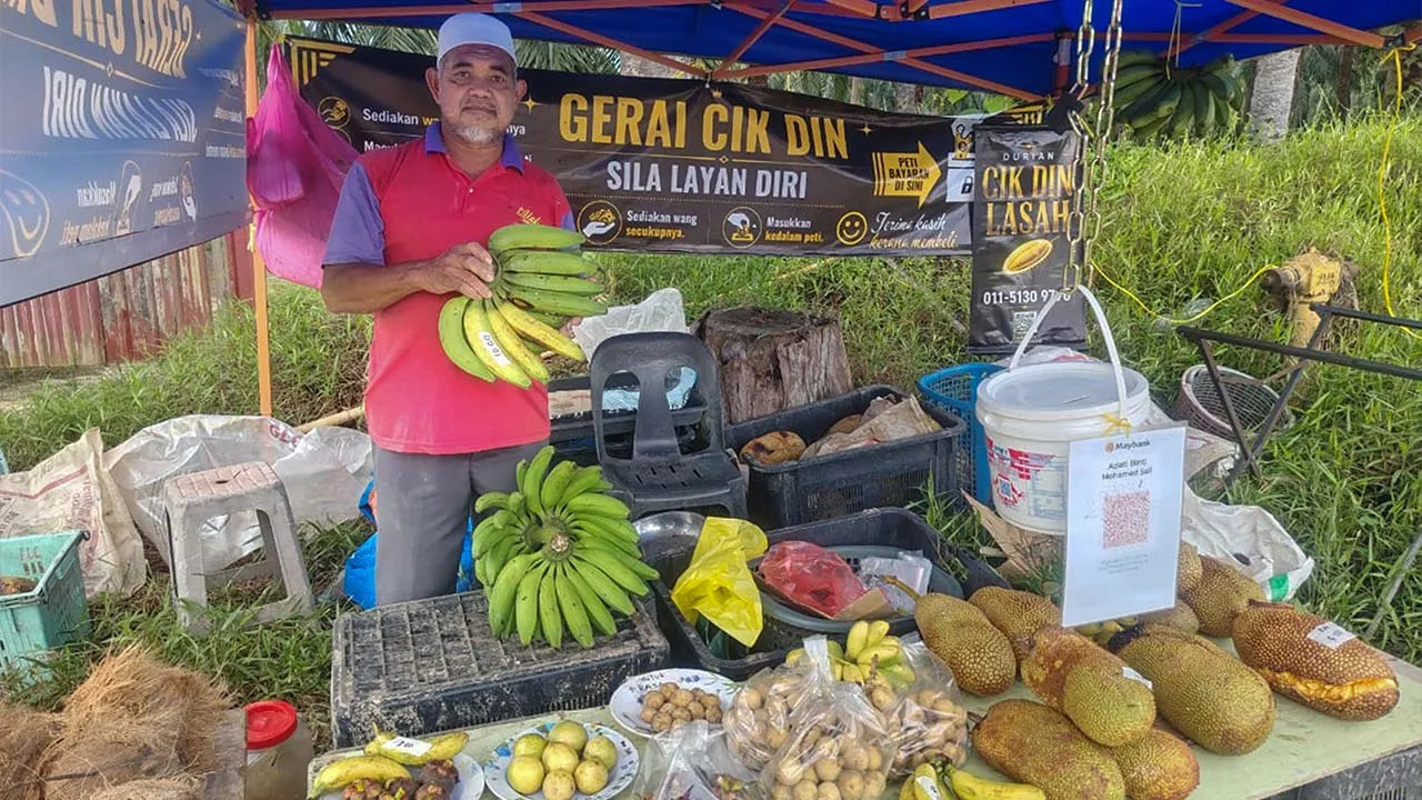 IPOH, 24 Julai -- Pemilik gerai Nordin Mat Yazid, 63, menunjukan buah-buahan yang dijual di premisnya di Kampung Lasah baru-baru ini.  Gerai buah-buahan berkonsepkan layan diri di di sini beroperasi sepenuhnya berlandaskan kejujuran serta kepercayaan terhadap pembeli.  Pelanggan boleh membuat pembayaran menerusi wang tunai diletakkan dalam tabung disediakan atau mengimbas kod QR yang disediakan.  -- fotoBERNAMA (2026) HAK CIPTA TERPELIHARA