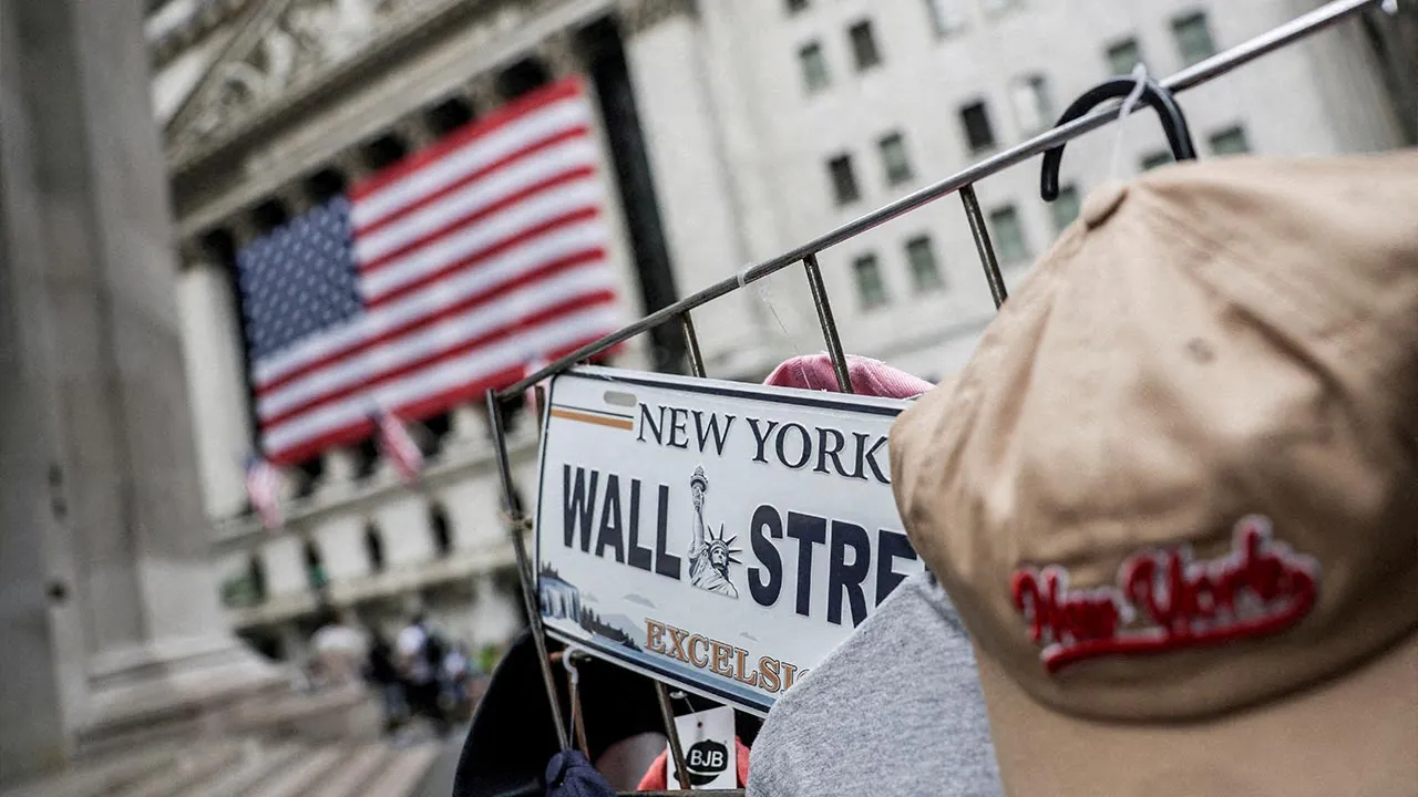 FILE PHOTO: A Wall Street plate is seen on a street vendor stall outside the New York Stock Exchange in New York City, U.S., July 11, 2025. REUTERS/Jeenah Moon/File Photo