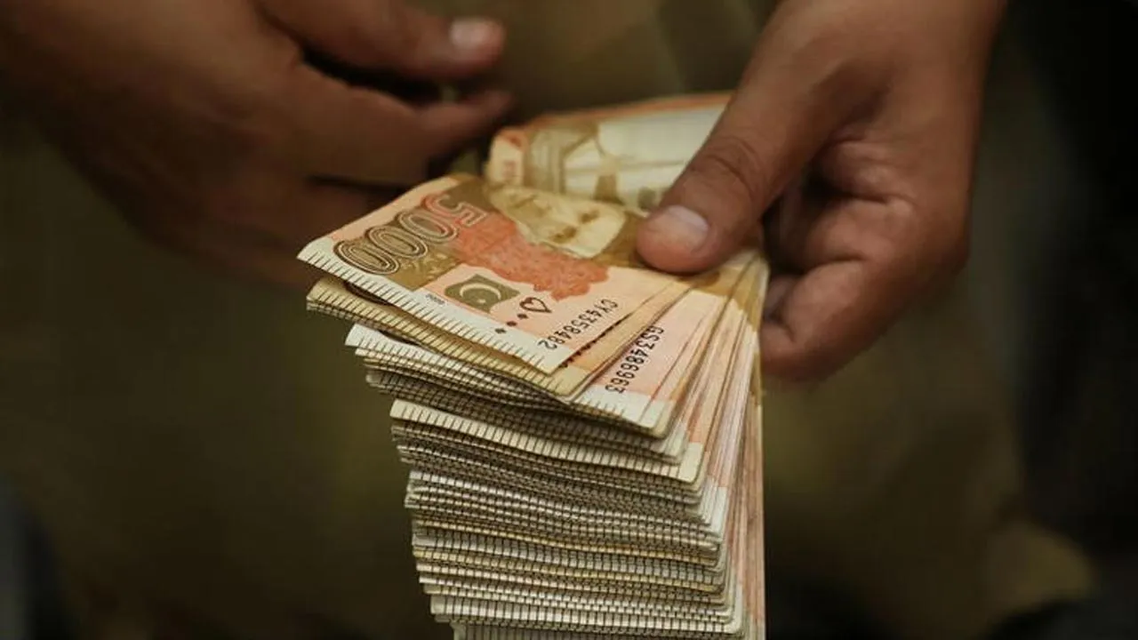 A trader counts Pakistani rupee notes at a currency exchange booth in Peshawar, Pakistan, July 29,2025. REUTERS/Fayaz Aziz