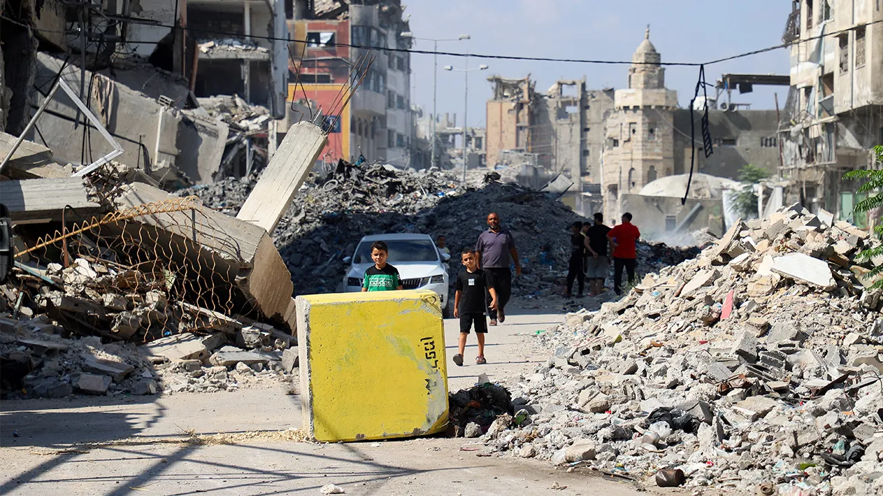 Palestinians look towards a yellow concrete block marking the "yellow zone" under Israeli military control, in Tufah neighborhood, in Gaza City, July 27, 2026. REUTERS