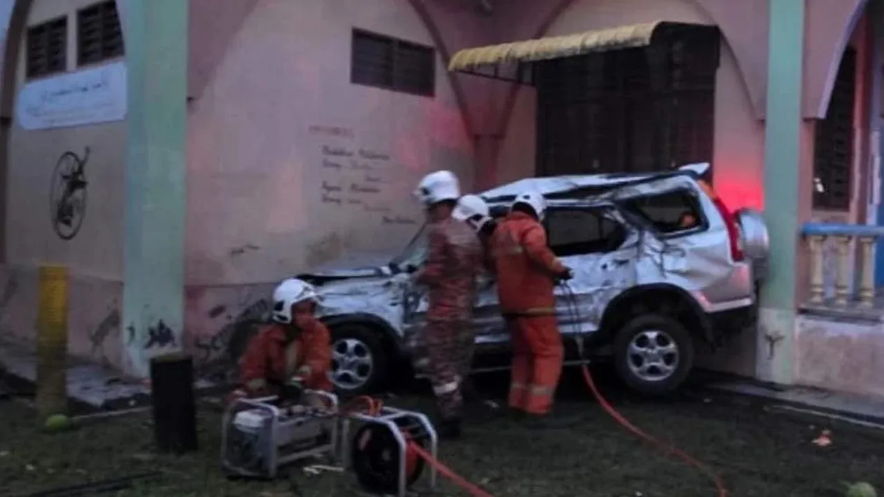 Anggota bomba mengeluarkan mangsa yang tersepit. Foto ihsan pembaca -- SINAR HARIAN