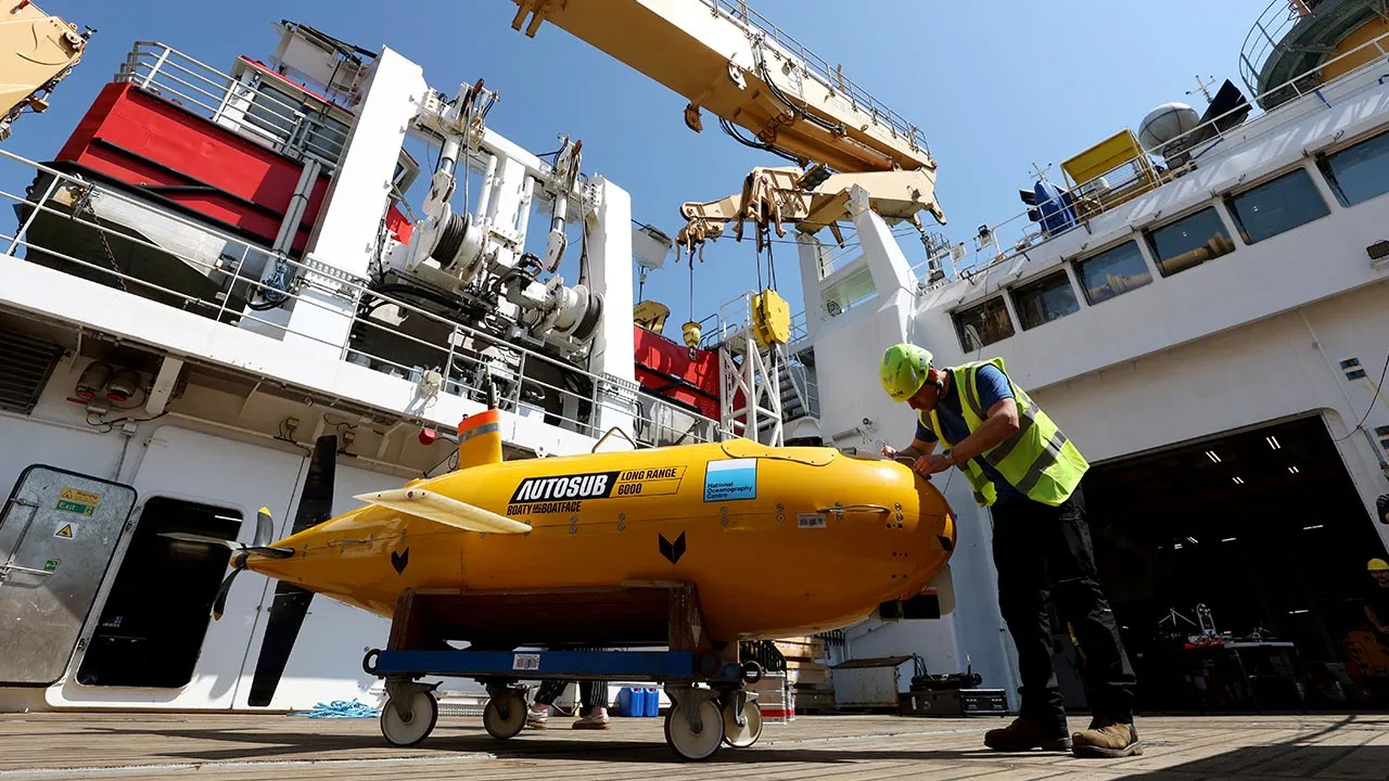 Sam Smith, an Operations Engineer, alongside Auto Sub Boaty McBoatface aboard the RRS Sir David Attenborough ahead of a mission to Greenland to study how warming affects the ice sheet and improve forecasts of its impact on the Atlantic, in Harwich, Britain, July 14, 2026. REUTERS/Chris Radburn