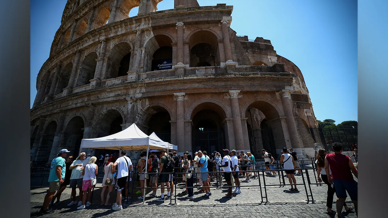 FILE PHOTO: Tourists queue under the sun outside the Colosseum during hot weather in Rome, Italy, June 20, 2026. REUTERS/Guglielmo Mangiapane/File Photo