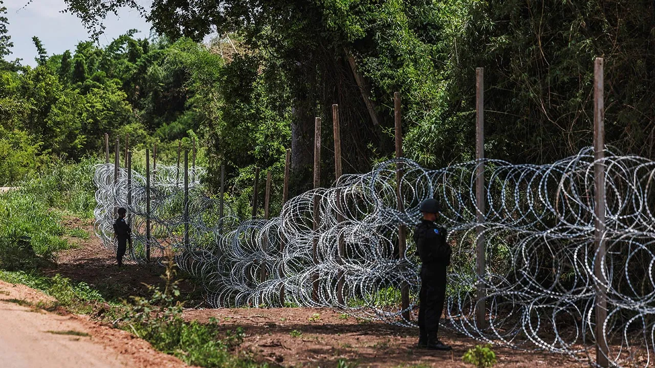 Thai soldiers stand guard beside concertina razor wire along the Thailand-Cambodia border in Pong Nam Ron district, Chanthaburi province, Thailand, July 22, 2026. REUTERS/Chalinee Thirasupa