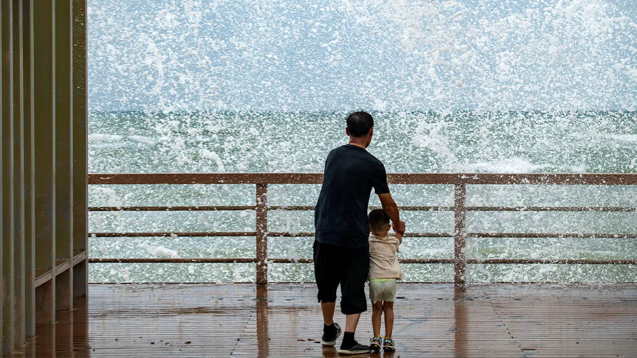 People watch waves crashing against the shore as Tropical Storm Maysak approaches in Boao, Qionghai, Hainan province, China, July 3, 2026. cnsphoto via REUTERS ATTENTION EDITORS - THIS IMAGE WAS PROVIDED BY A THIRD PARTY. CHINA OUT. NO COMMERCIAL OR EDITORIAL SALES IN CHINA