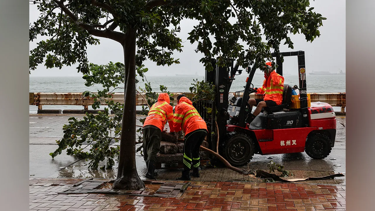 Workers clear fallen debris and obstacles from the road after Typhoon Noul, in Hong Kong, China, July 26, 2026. REUTERS/Tyrone Siu