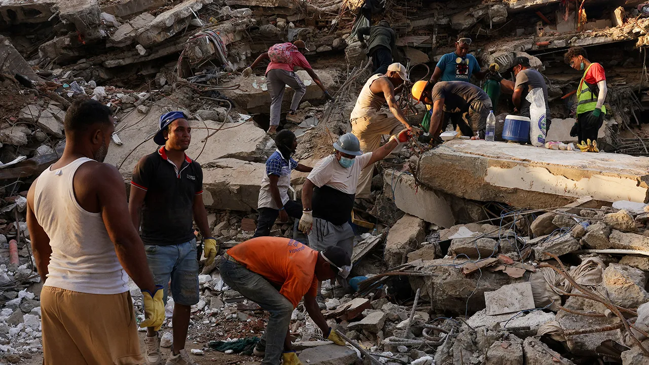 People work together as they search for their loved ones amid debris, in the aftermath of the June 24 earthquakes, at Tanaguarena, in La Guaira, Venezuela, July 12, 2026. REUTERS/Gaby Oraa